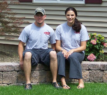 Greg and his wife sitting on a retaining wall they built