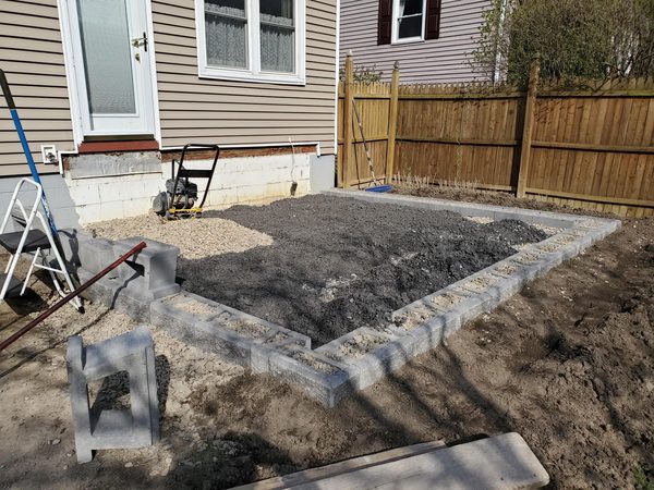 Dark gravel fill compacted inside wall frame