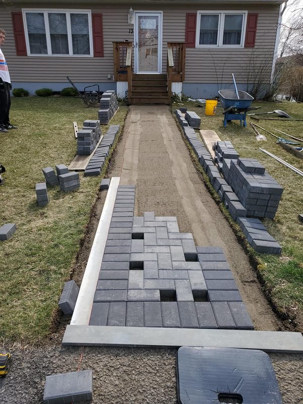 Sand leveling in progress, first pavers being laid