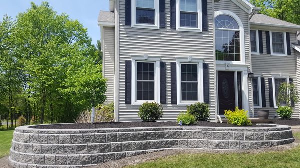 Curved block retaining wall with mulch and landscaping