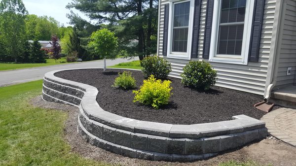 Close-up of curved retaining wall blocks with mulch
