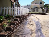 Stone retaining wall along driveway with steps